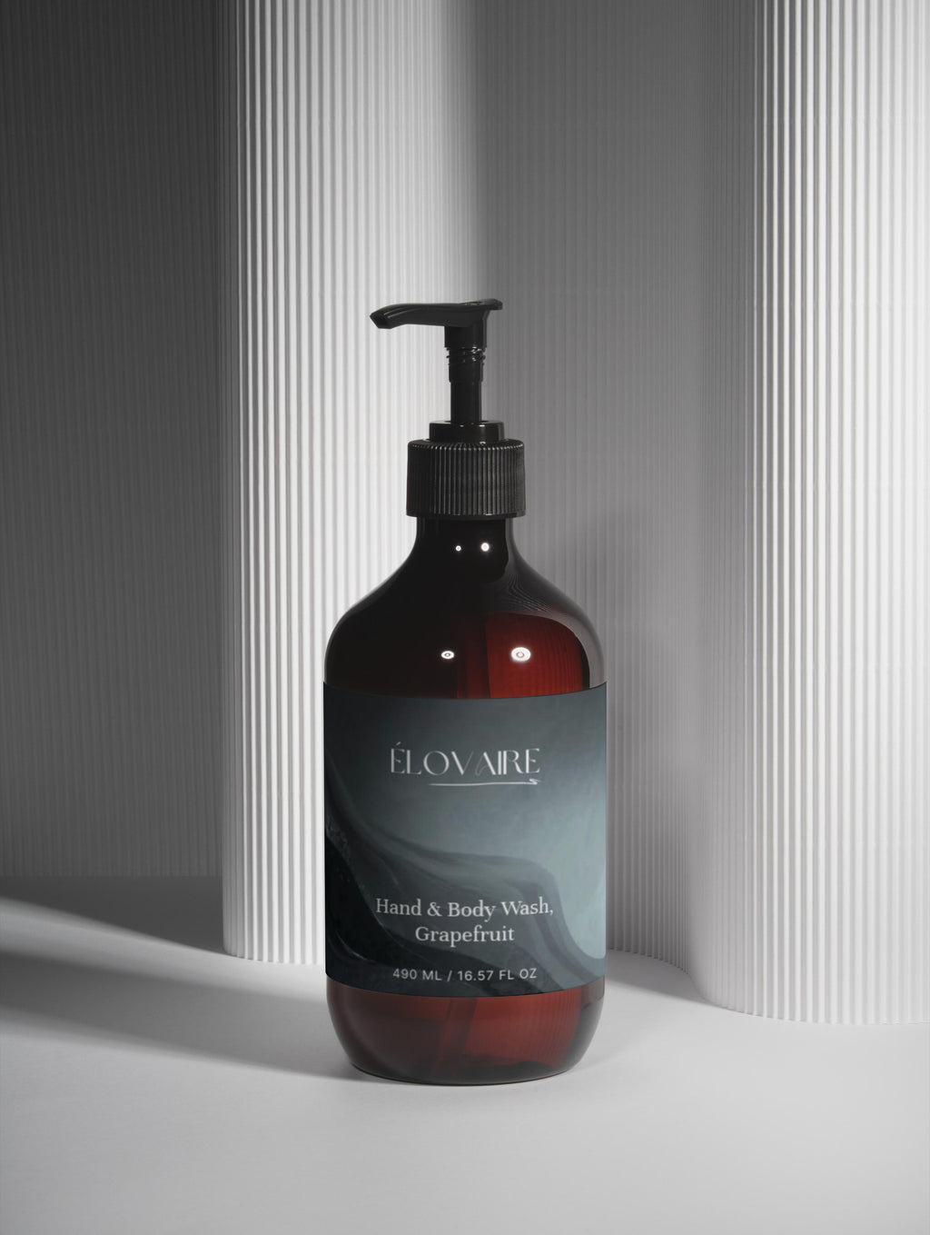 Bottle of ELOVAIRE hand and body wash with grapefruit scent on a neutral background